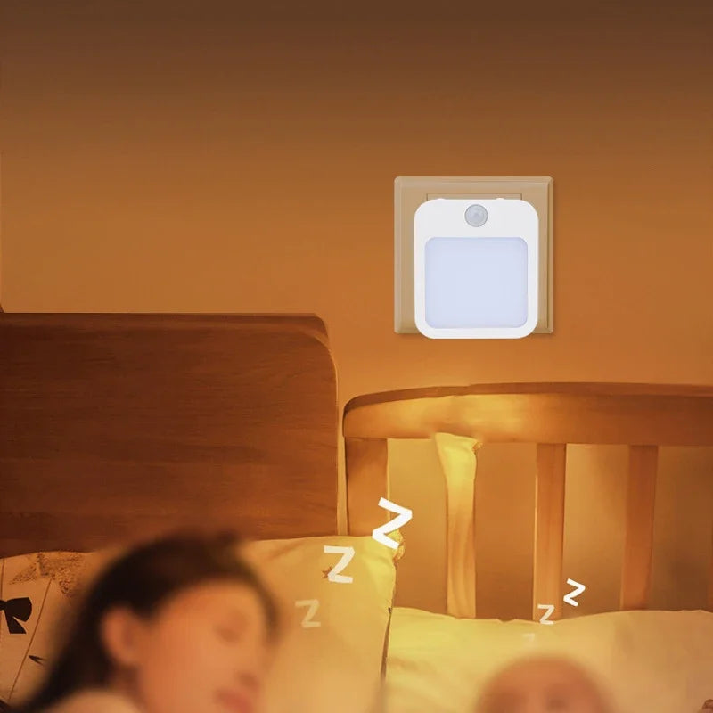 Motion Sensor Night Light casting a soft warm glow over a child asleep in bed