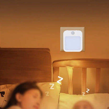 Motion Sensor Night Light casting a soft warm glow over a child asleep in bed