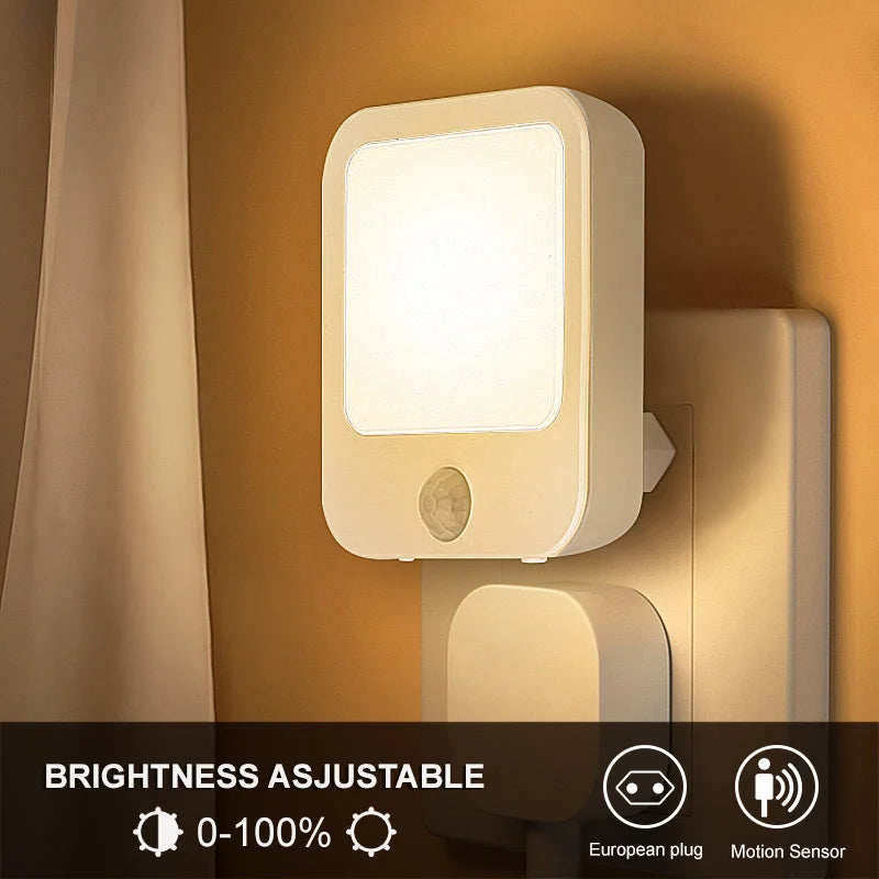 Motion Sensor Night Light glowing warm in a wall socket beside a curtain